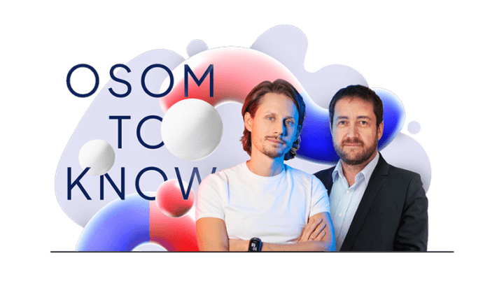 Two men stand together in front of a colorful abstract background featuring spheres and gradient shapes. One wears a white t-shirt, and the other is in a suit. The text "OSOM TO KNOW" is partially visible behind them.